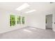 Bedroom featuring neutral carpet, skylights, and a window at 304 W Kirkfield Dr, Cary, NC 27518