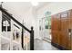 Bright foyer with elegant staircase and a wood front door leading to outside at 304 W Kirkfield Dr, Cary, NC 27518