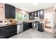 Stylish kitchen with brick walls, sleek black cabinetry, stainless steel appliances, and tile floors at 304 W Kirkfield Dr, Cary, NC 27518
