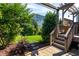 The manicured backyard has a stone patio, lush greenery, and pergola at 3128 Mountain Hill Dr, Wake Forest, NC 27587