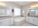 Bright bathroom with dual sinks, large soaking tub, and modern fixtures at 3128 Mountain Hill Dr, Wake Forest, NC 27587