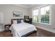 Well-lit bedroom features a bed, a side table, and a desk by the window at 3128 Mountain Hill Dr, Wake Forest, NC 27587