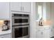 Stainless steel double ovens are featured in a kitchen with white cabinets and countertop at 3128 Mountain Hill Dr, Wake Forest, NC 27587