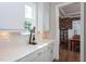 White cabinets, countertops, and tile backsplash enhance a kitchen with a view of a formal dining room at 3128 Mountain Hill Dr, Wake Forest, NC 27587
