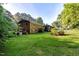 Expansive backyard featuring a screened porch, mature trees, and green grass at 3329 Broughton Dr, Durham, NC 27704