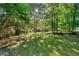 Secluded backyard with mature trees providing shade and privacy, perfect for relaxation at 3329 Broughton Dr, Durham, NC 27704