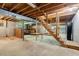 Unfinished basement features exposed wood beams and stairs to upper level at 3329 Broughton Dr, Durham, NC 27704