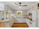 Well-lit kitchen with white cabinetry, hardwood floors, and a breakfast bar offering ample space at 3329 Broughton Dr, Durham, NC 27704
