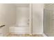 Bright bathroom featuring a soaking tub and a glass-enclosed shower stall at 350 Pillow Ln, Burlington, NC 27217