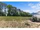 Landscaped backyard with patio furniture, blue umbrella, and a view of the wooded area at 351 Lowery Ln, Benson, NC 27504