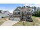 Inviting home featuring a two-car garage, stone accents, covered porch, and manicured landscaping at 351 Lowery Ln, Benson, NC 27504