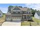 Charming two-story home featuring a welcoming front porch, three-car garage, and well-manicured lawn at 351 Lowery Ln, Benson, NC 27504