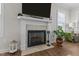 Close up of fireplace with tile surround, mantel, and a large plant next to it at 351 Lowery Ln, Benson, NC 27504