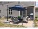 Backyard patio with umbrella-covered table and grill adjacent to the screened porch of this inviting home at 351 Lowery Ln, Benson, NC 27504