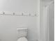 Bathroom showcasing a white toilet, white walls, with a shower curtain, and a row of hooks for towels at 418 S West St, Cary, NC 27511