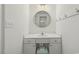 Bathroom vanity featuring a round mirror, white countertop, and storage cabinets with a view to the shower at 418 S West St, Cary, NC 27511
