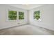 Bright bedroom featuring neutral carpet, white walls, and sun-filled windows offering ample natural light at 418 S West St, Cary, NC 27511