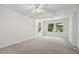 Bright bedroom featuring neutral carpet, fresh white walls, a ceiling fan, and sun-filled windows at 418 S West St, Cary, NC 27511