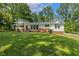 Charming home featuring a brick foundation, white siding, a well-maintained lawn, and mature shade trees at 418 S West St, Cary, NC 27511