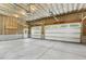 Spacious and unfinished garage featuring two automatic doors, unfinished ceilings, and natural light at 418 S West St, Cary, NC 27511