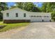 Spacious three car garage with white doors and siding and partial brick facade at the base at 418 S West St, Cary, NC 27511