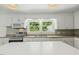 Bright kitchen showcasing white cabinetry, stainless steel appliances, and a double-window over the sink at 418 S West St, Cary, NC 27511