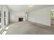 Spacious living room featuring plush carpeting, a cozy fireplace, and ample natural light at 418 S West St, Cary, NC 27511