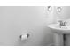 Bathroom featuring a pedestal sink, toilet paper holder, and round mirror at 421 Wait Ave # 100, Wake Forest, NC 27587