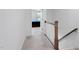 Hallway with carpeted floors, wooden staircase, and doorway leading to a bedroom at 421 Wait Ave # 100, Wake Forest, NC 27587