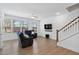 Living room with hardwood floors, comfortable seating, ceiling fan, and large windows at 421 Wait Ave # 100, Wake Forest, NC 27587