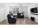 Bright living room featuring hardwood floors, a ceiling fan, and natural light from large windows at 421 Wait Ave # 100, Wake Forest, NC 27587