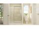 Bright bathroom featuring a glass-enclosed shower, toilet, and a large window for natural light at 43 Regal Gardens Ct, Angier, NC 27501