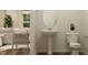Stylish powder room featuring a pedestal sink, oval mirror, and a view into the cozy living area at 43 Regal Gardens Ct, Angier, NC 27501
