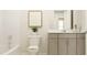 Bright bathroom featuring a gray vanity, a white toilet, and bathtub with shower at 43 Regal Gardens Ct, Angier, NC 27501