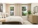 Cozy bedroom featuring a bed, nightstands, lamps, decor, and two large windows at 43 Regal Gardens Ct, Angier, NC 27501