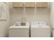 Functional laundry room with white washer and dryer, storage shelves, and ample space for sorting laundry at 43 Regal Gardens Ct, Angier, NC 27501