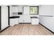 Basement kitchenette features white cabinets, sleek countertops, and tile floors at 4605 Malor Dr, Wake Forest, NC 27587