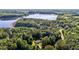 Scenic aerial view of a home nestled among lush green trees near a tranquil lake at 4701 Governor Hunt St, Efland, NC 27243