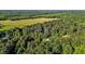 Lush aerial view of a home among a mix of dense forest and open green pasture land at 4701 Governor Hunt St, Efland, NC 27243