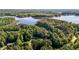 An aerial view of a wooded property with a lake in the background on a sunny day at 4701 Governor Hunt St, Efland, NC 27243