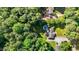 Aerial view of a home with an in-ground pool in a green backyard surrounded by mature trees at 4701 Governor Hunt St, Efland, NC 27243
