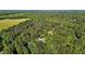 An aerial view of a tree-covered lot with a home on it, and some cleared land nearby at 4701 Governor Hunt St, Efland, NC 27243