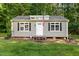 Charming cottage with an American flag, black shutters and well-maintained landscape at 4701 Governor Hunt St, Efland, NC 27243