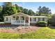 Charming ranch home with a welcoming front porch and lush, mature landscaping at 4701 Governor Hunt St, Efland, NC 27243