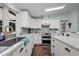 Bright kitchen featuring white cabinetry, grey subway tile backsplash, and wood floors at 4701 Governor Hunt St, Efland, NC 27243