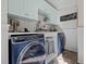 Inviting laundry room featuring modern, front-loading washer and dryer with ample counter space and storage cabinets at 4701 Governor Hunt St, Efland, NC 27243