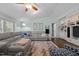 Cozy living room featuring a gray sectional couch, decorative pillows, and a ceiling fan at 4701 Governor Hunt St, Efland, NC 27243