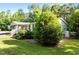 Landscaped yard with lush trees and green lawn surrounding home's exterior at 4701 Governor Hunt St, Efland, NC 27243
