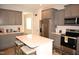 Stylish kitchen featuring gray cabinets, stainless steel appliances, and a center island at 474 Ashpole Trl, Clayton, NC 27520