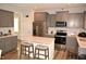 Modern kitchen with stainless steel appliances, gray cabinets, and a center island with seating at 474 Ashpole Trl, Clayton, NC 27520